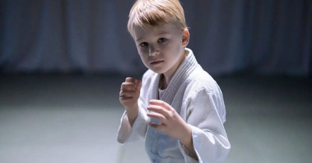 Child practicing a ready stance while learning martial arts basics