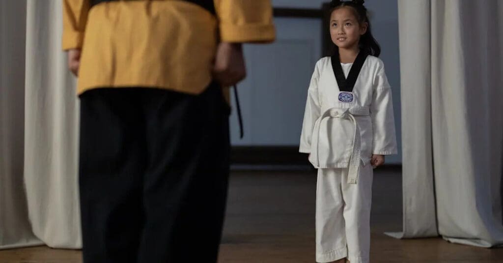 Young student listening to an instructor before beginner martial arts training