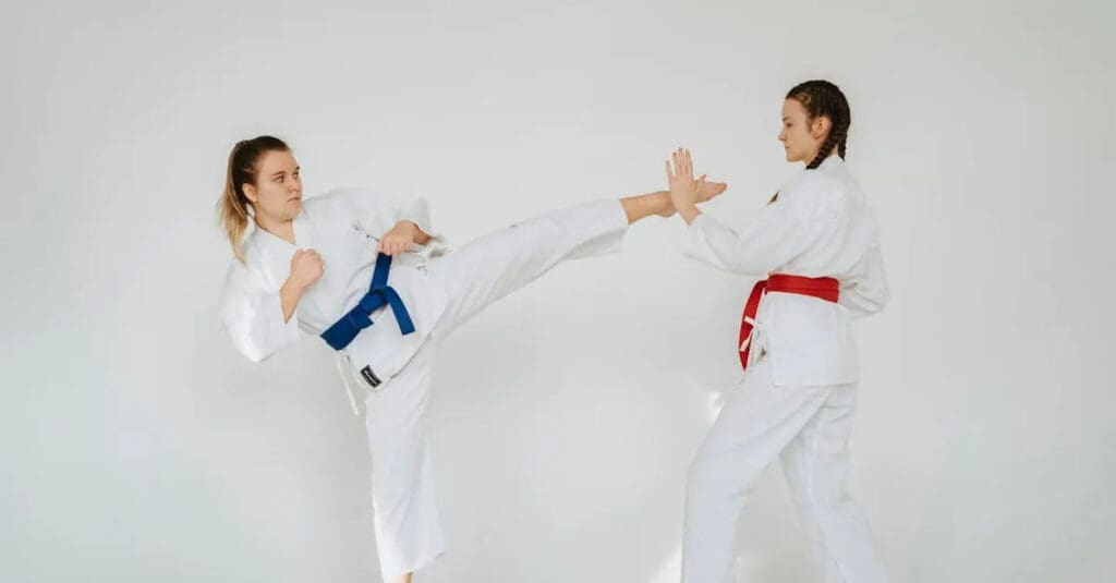 Student practicing a controlled kick with a partner during beginner martial arts training