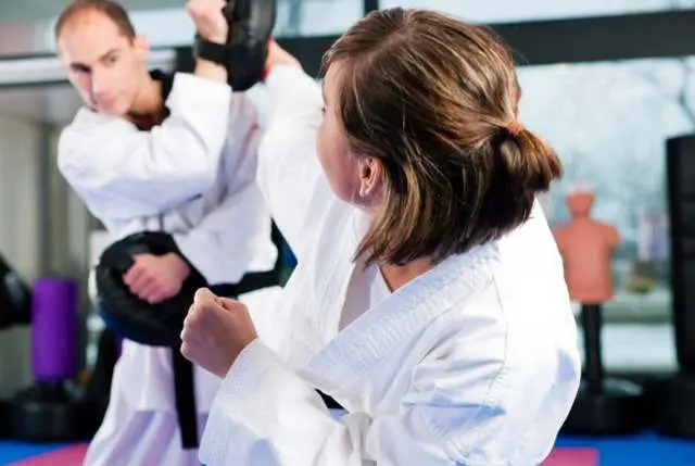 student practicing high kick for adult martial arts class