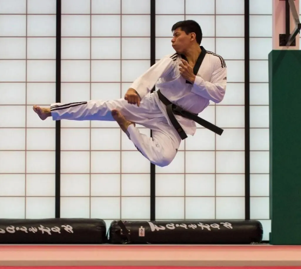 adult doing flying kicks during adult karate lessons